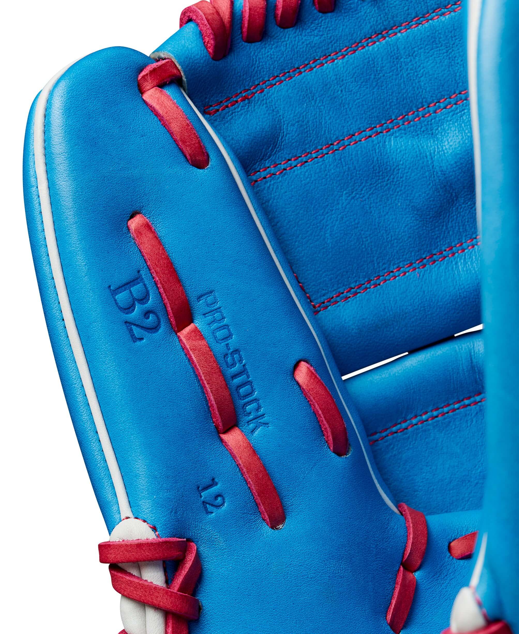Close-up of the Wilson A2000 B2 pitcher's baseball glove in Autism Speaks blue with pink accents and Pro Stock leather detail.