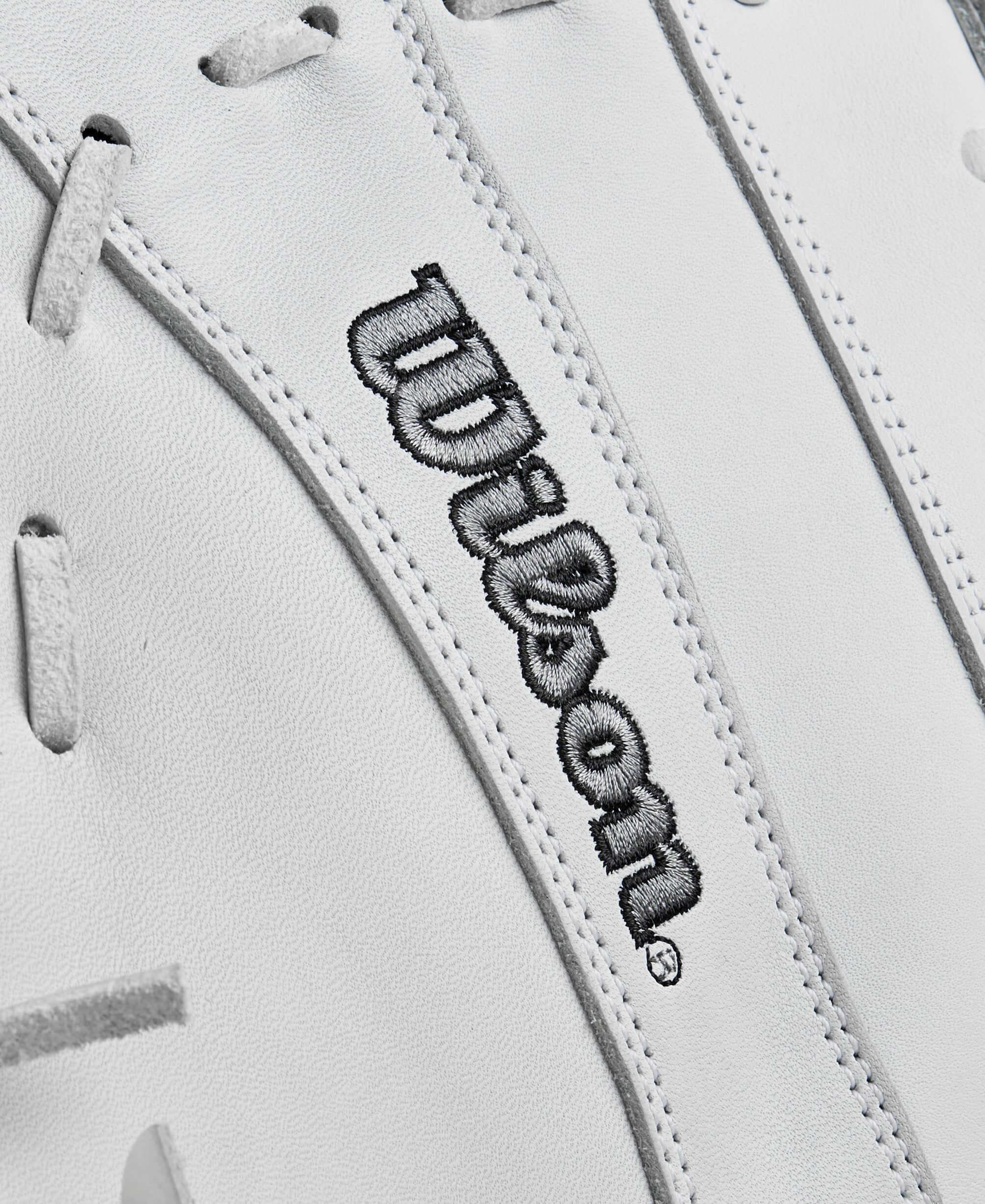 Close-up of Wilson logo on white leather Fastpitch softball glove for optimal performance.