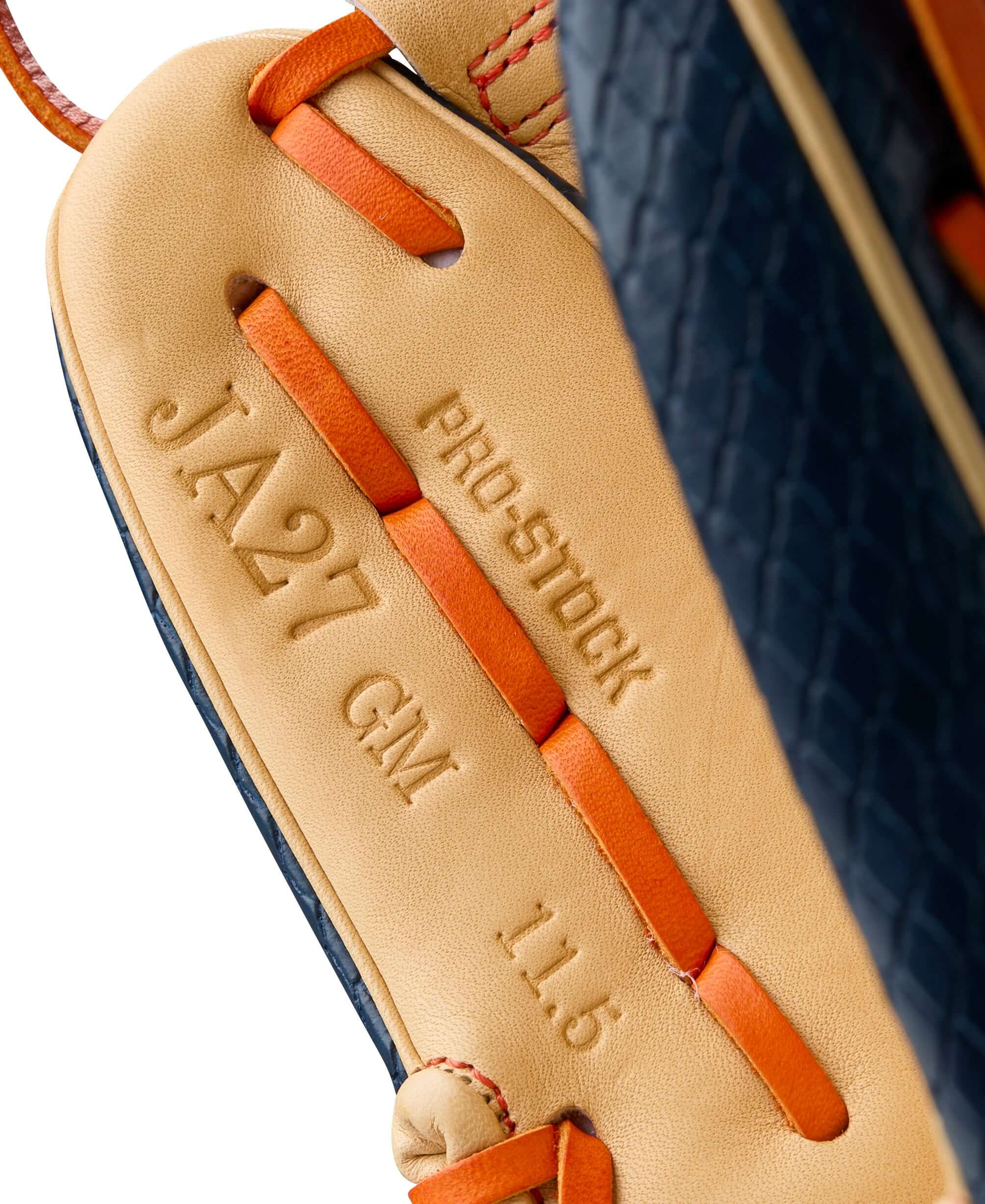Close-up of Wilson A2000 JA27 Pro Stock glove showing branding and specifications, 11.5 inch size in navy and blonde colors.