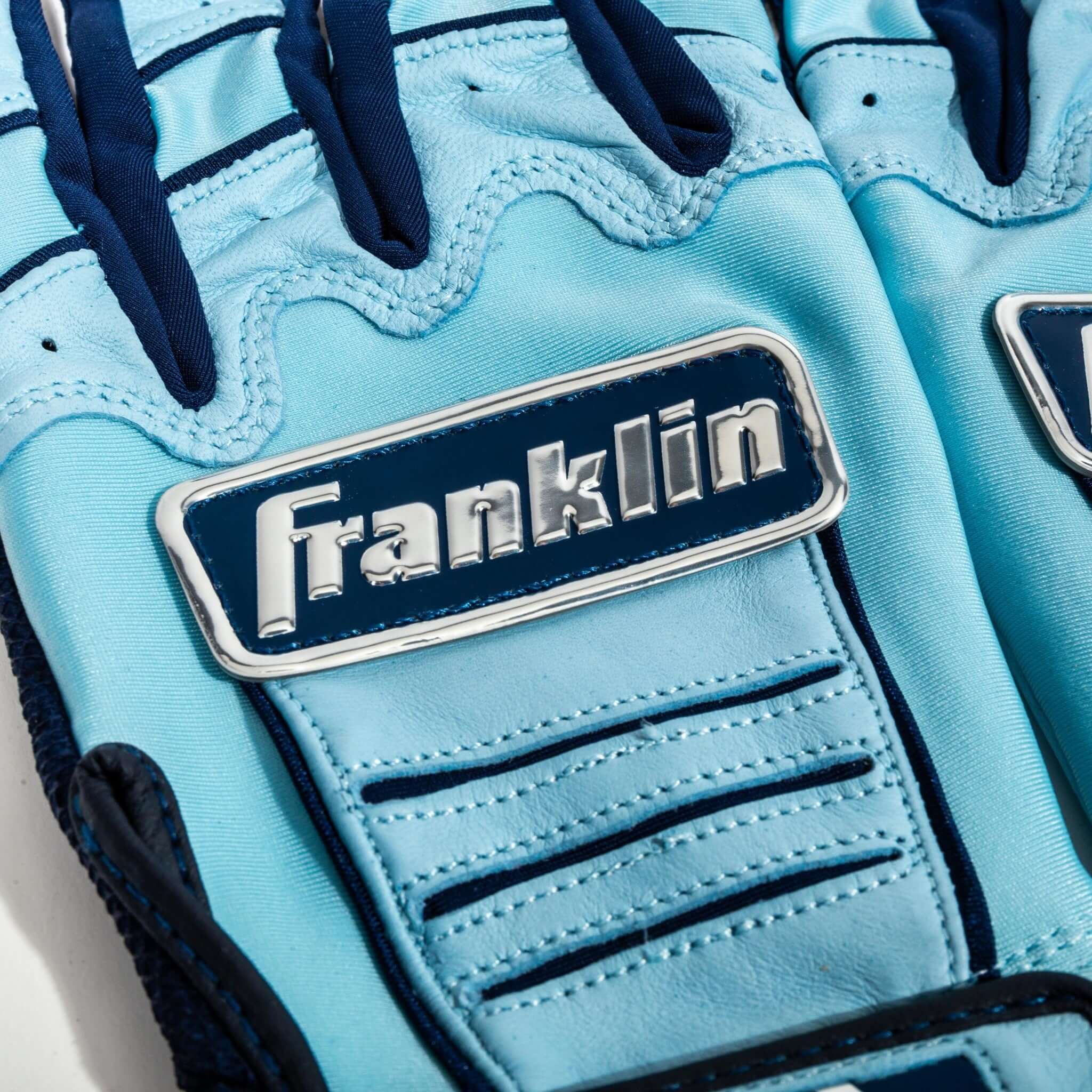 Navy Franklin chrome logo batting gloves with Carolina blue accents.