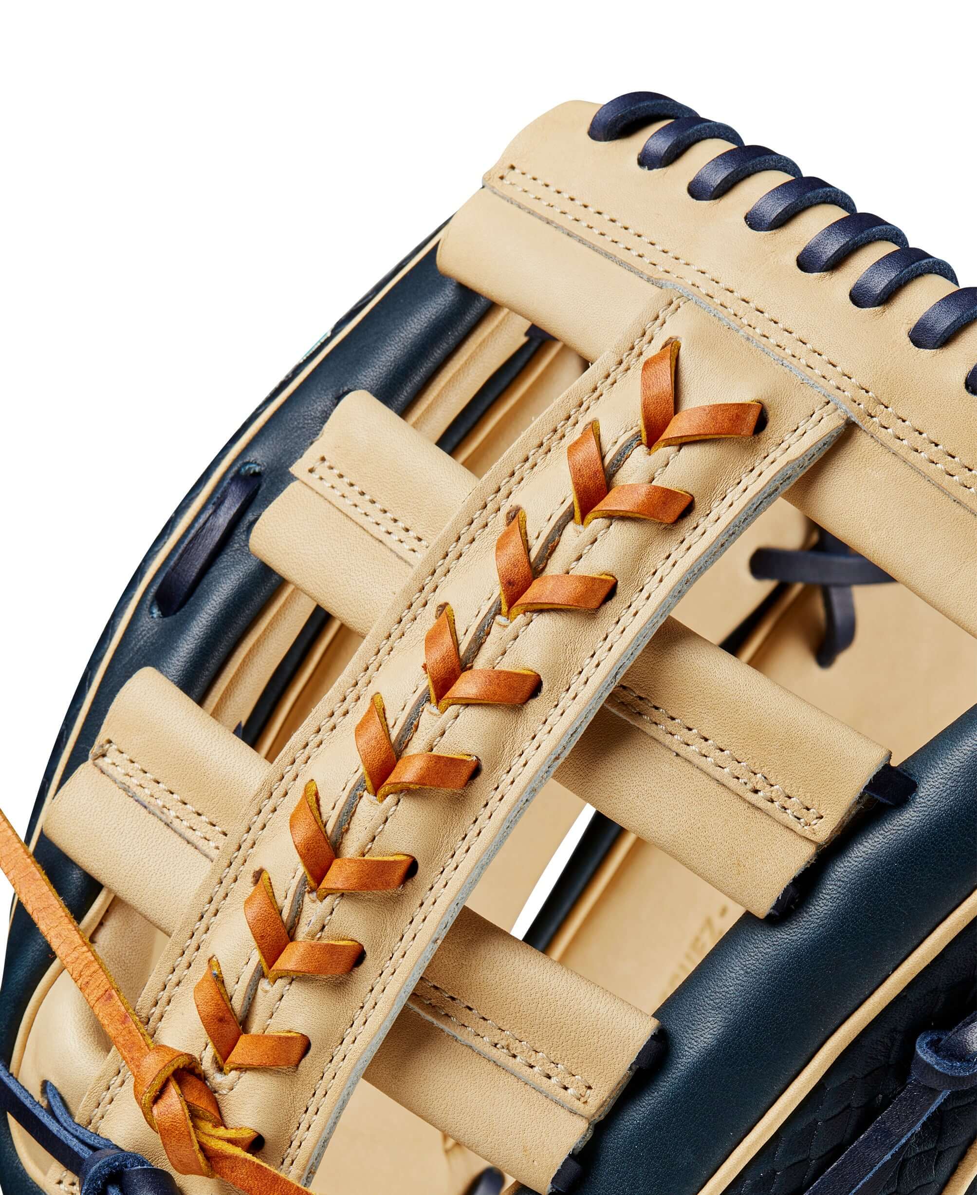 Close-up view of the Wilson 2024 A2000 Julio Rodriguez glove showcasing its navy blue and blonde leather design and lace details.