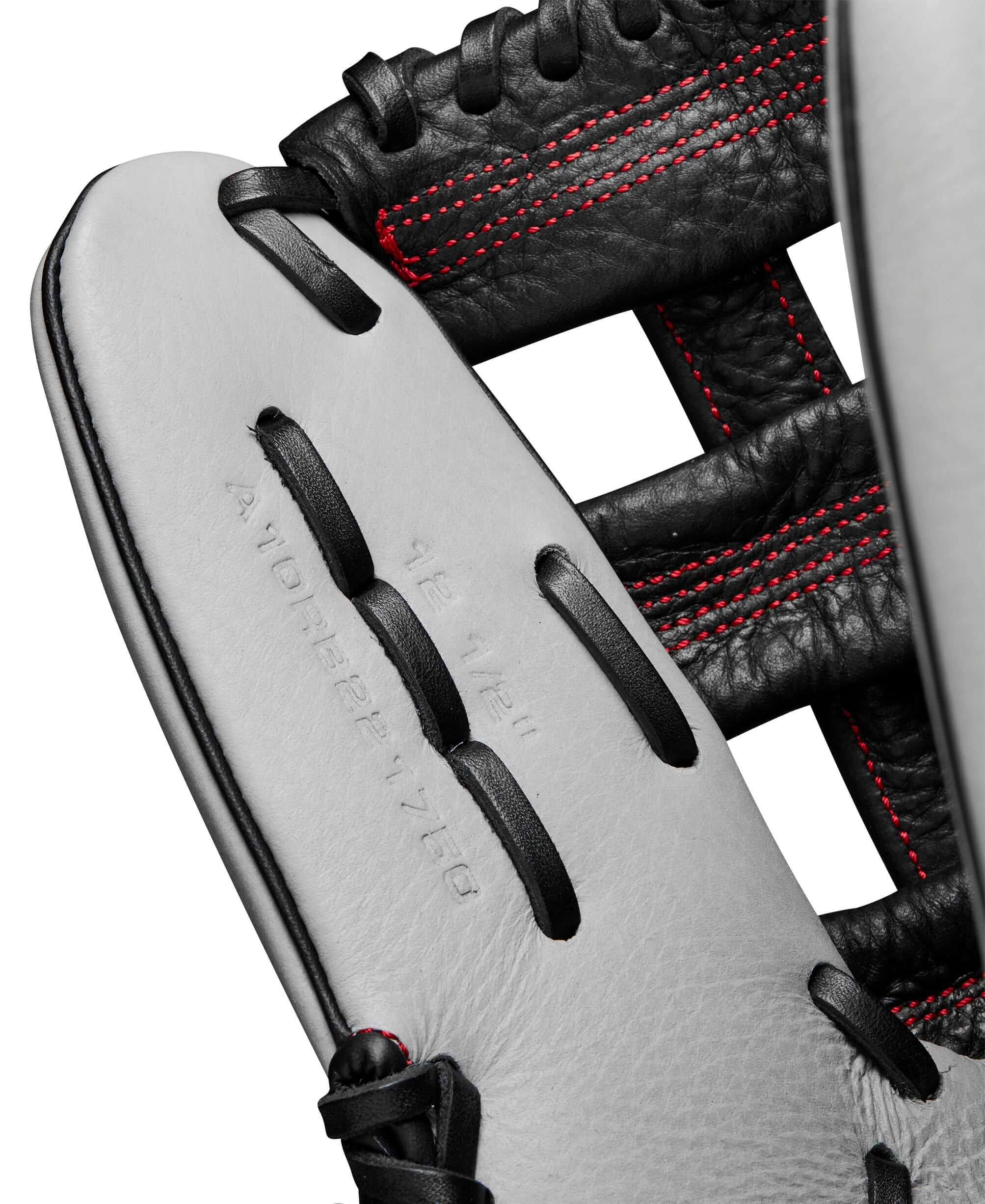 Close-up of Wilson 2024 A1000 1750 baseball glove, showcasing silver leather and red stitching details.