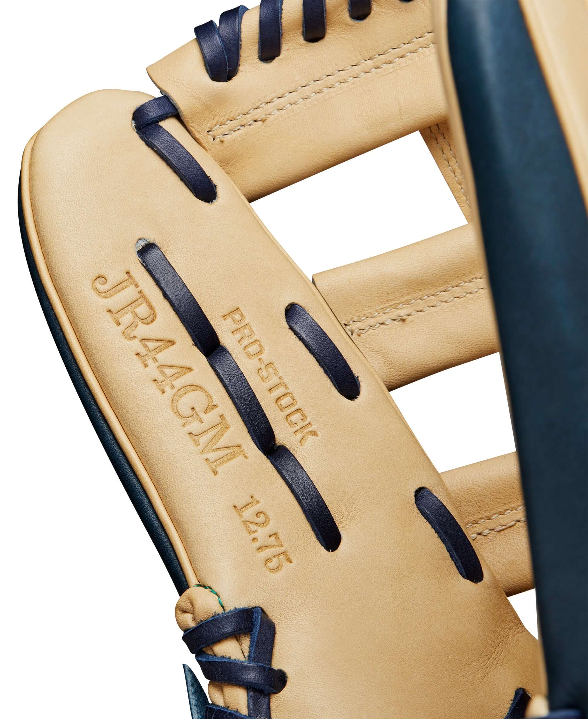Close-up of the Wilson A2000 JR44 GM glove showing the Pro Stock label and 12.75 inch size in Navy Blue and Blonde.