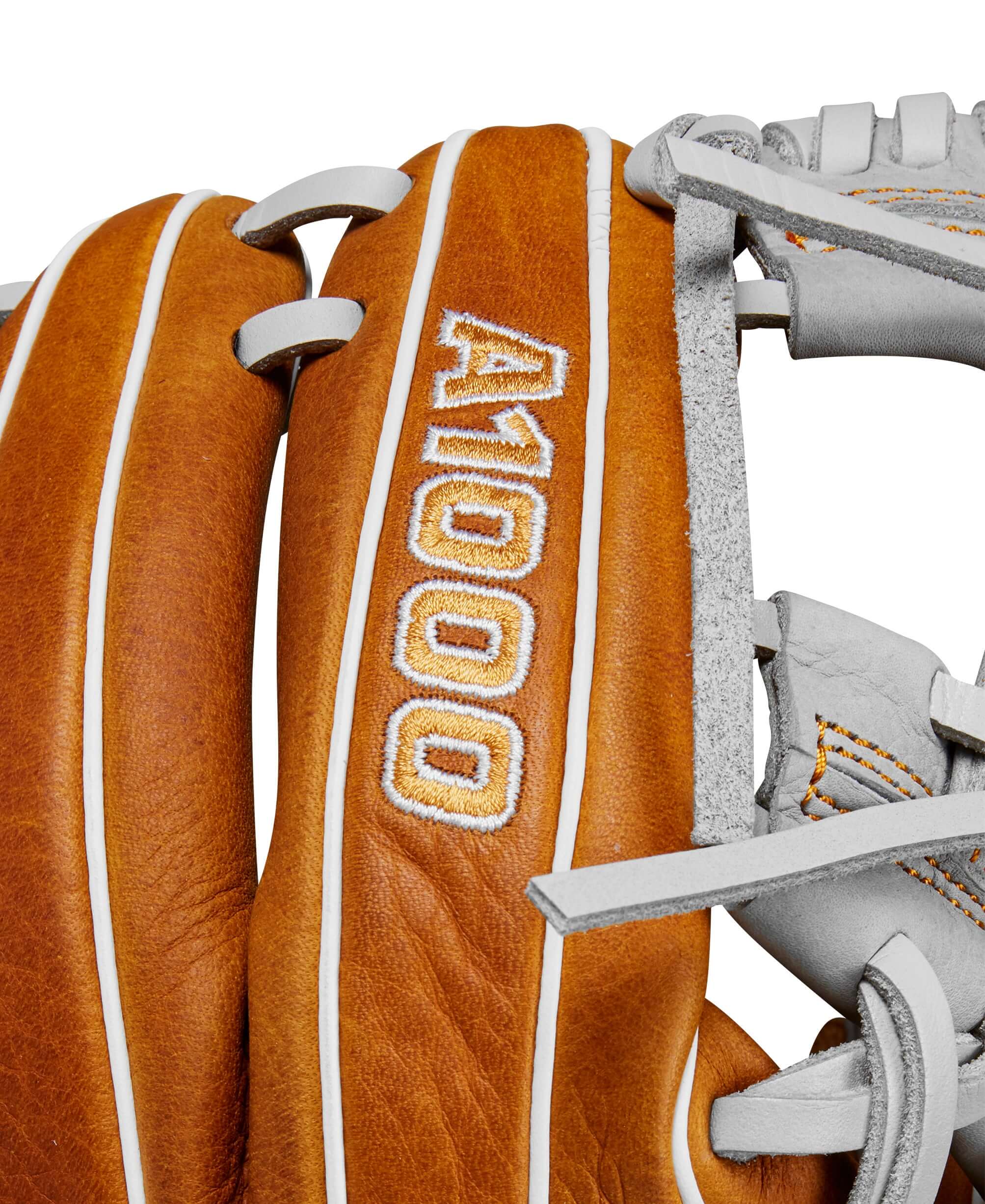 Close-up of Wilson A1000 infield baseball glove showing saddle tan leather and detail stitching.