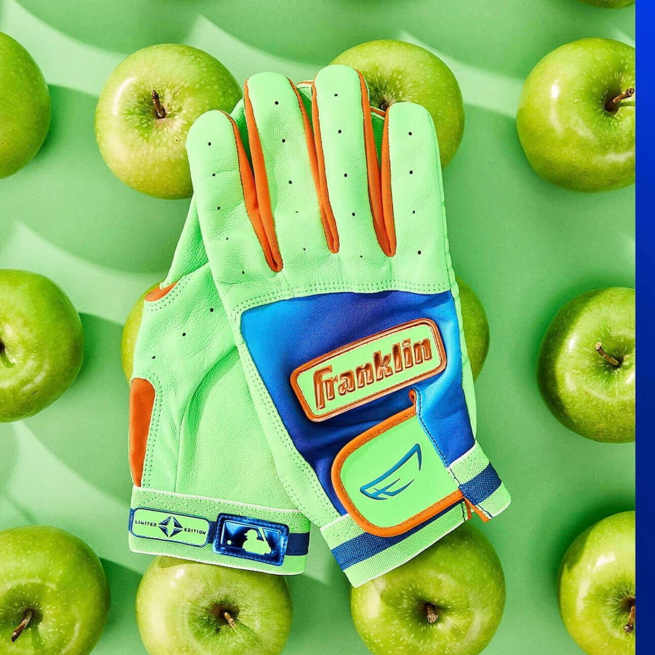 Franklin Lindor limited edition youth batting gloves in vibrant green and blue, surrounded by green apples.