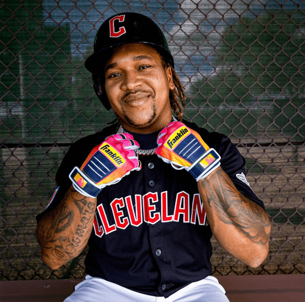 Franklin Jose Ramirez Limited Edition CFX Pro Youth gloves in Citrus Dawn, worn by player showing palm view with team jersey.