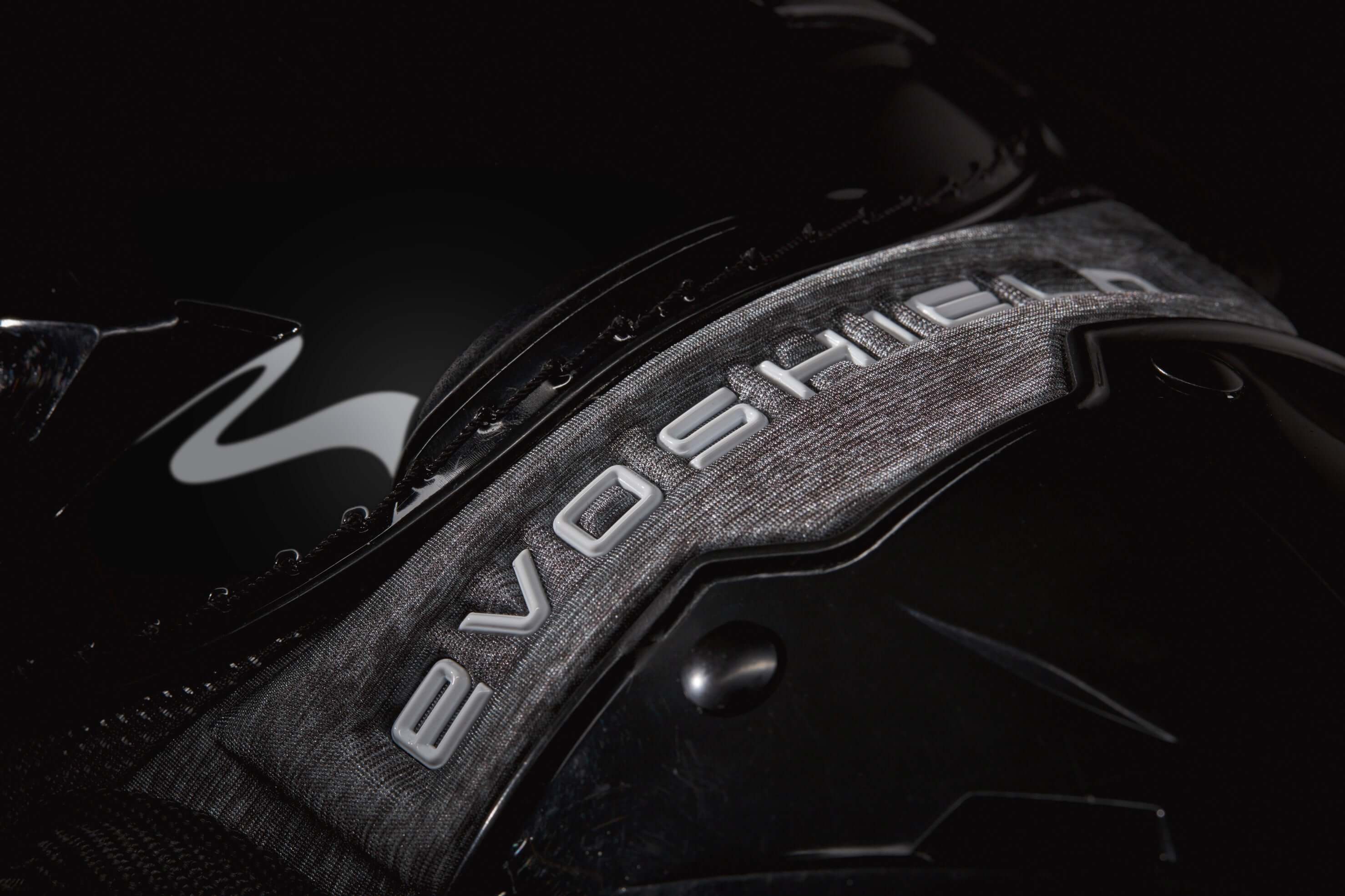 Close-up of Evoshield logo on black baseball gear, highlighting Pro-SRZ design and materials for catchers.