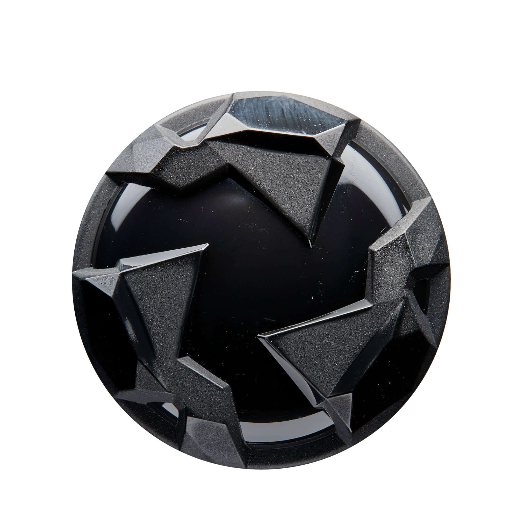 Black round decorative element with geometric patterns and a glossy finish.