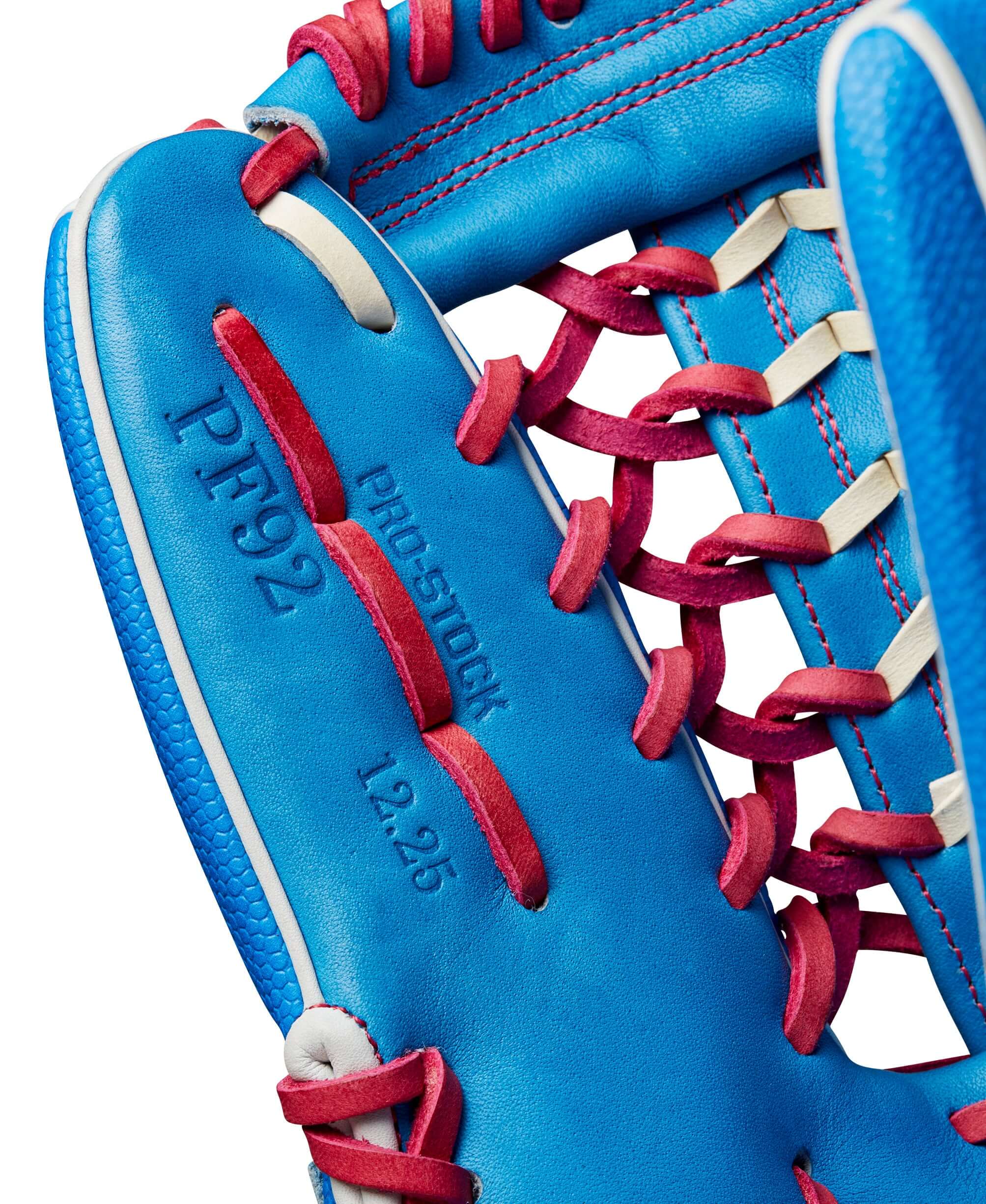 Close-up of Wilson A2000 PF92SS glove with blue leather and red stitching, showcasing Pro Stock features and 12.25” size.