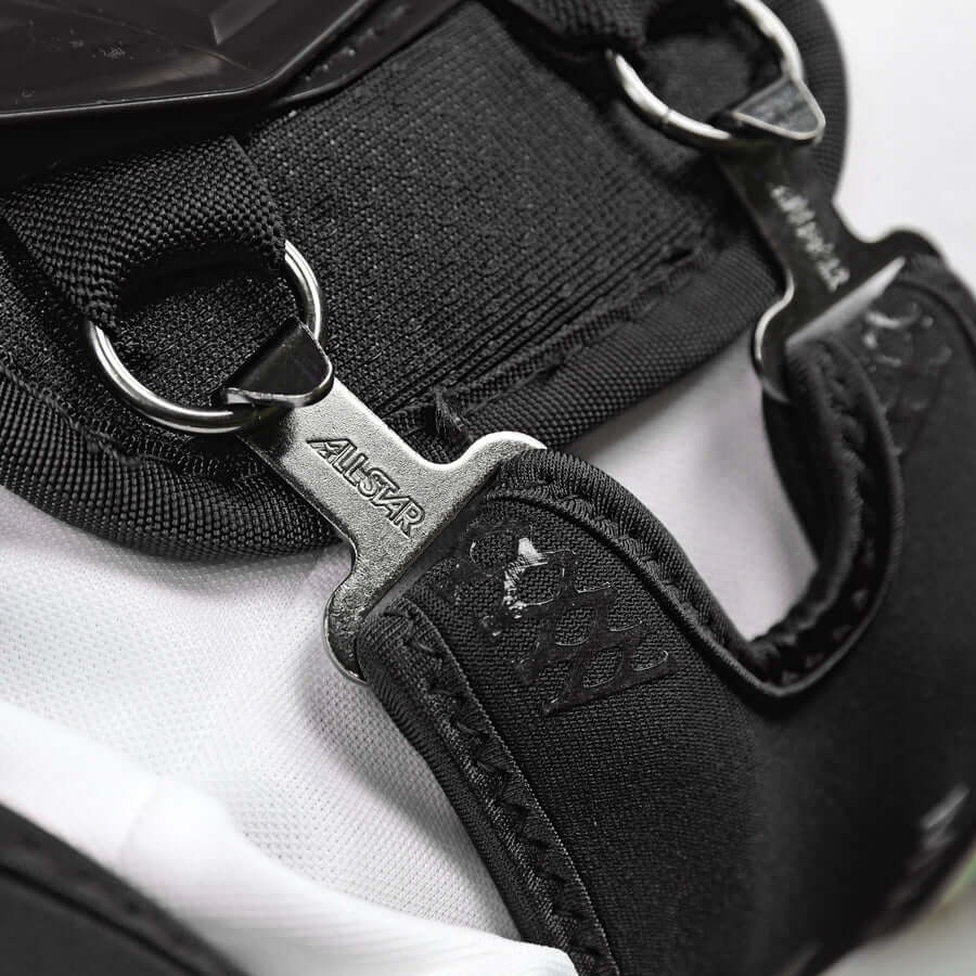 Close-up of All-Star MVP-PRO™ Catcher Leg Guards strap detail in Black/Black, showing interlocking hardware.
