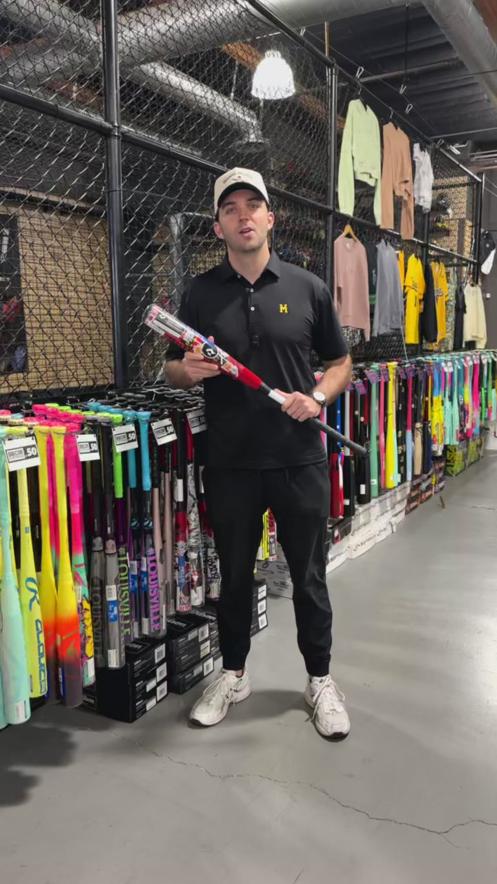 Person holding 2026 DeMarini The Goods Sticker Bomb (-3) BBCOR Baseball Bat in a store