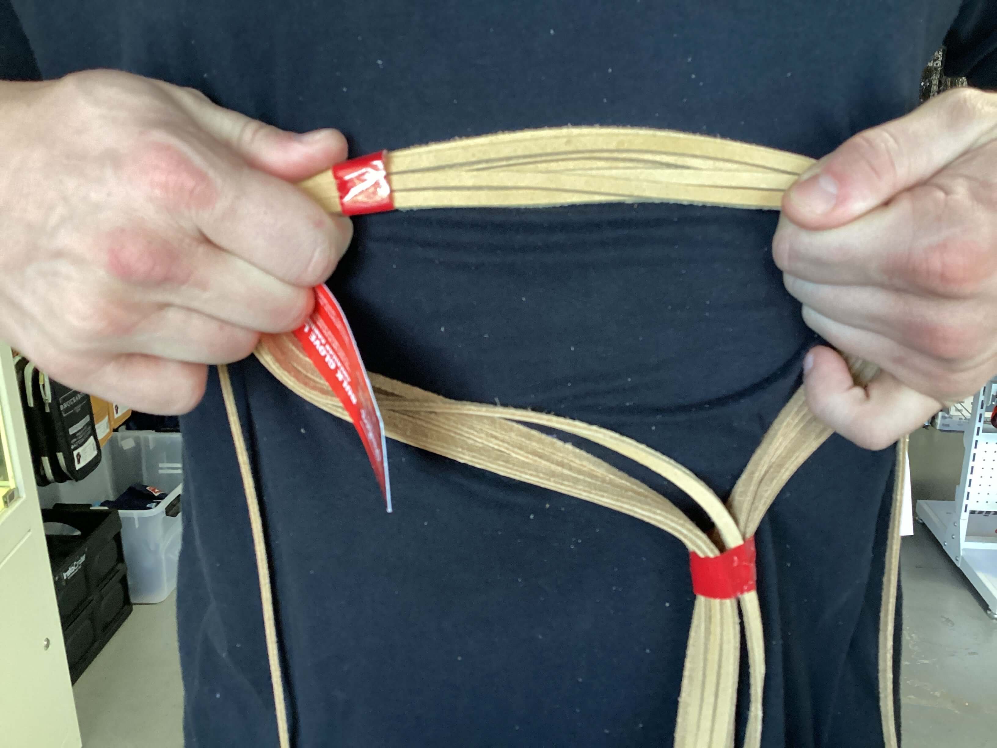 Person holding Rawlings 3/16" rawhide lace for baseball glove replacement, showcasing its 72" length and genuine material.