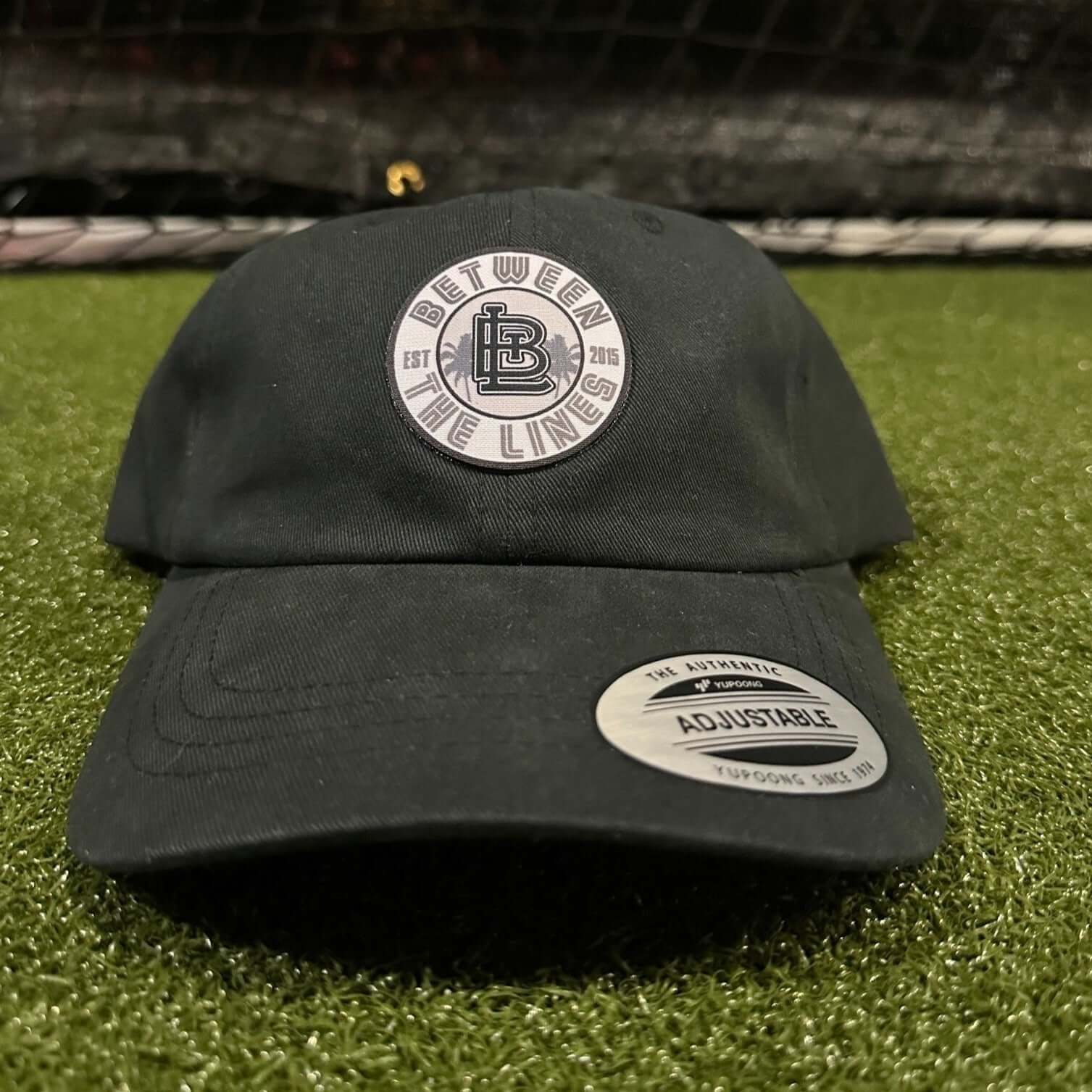 Black adjustable hat with brand logo badge, 100% cotton
